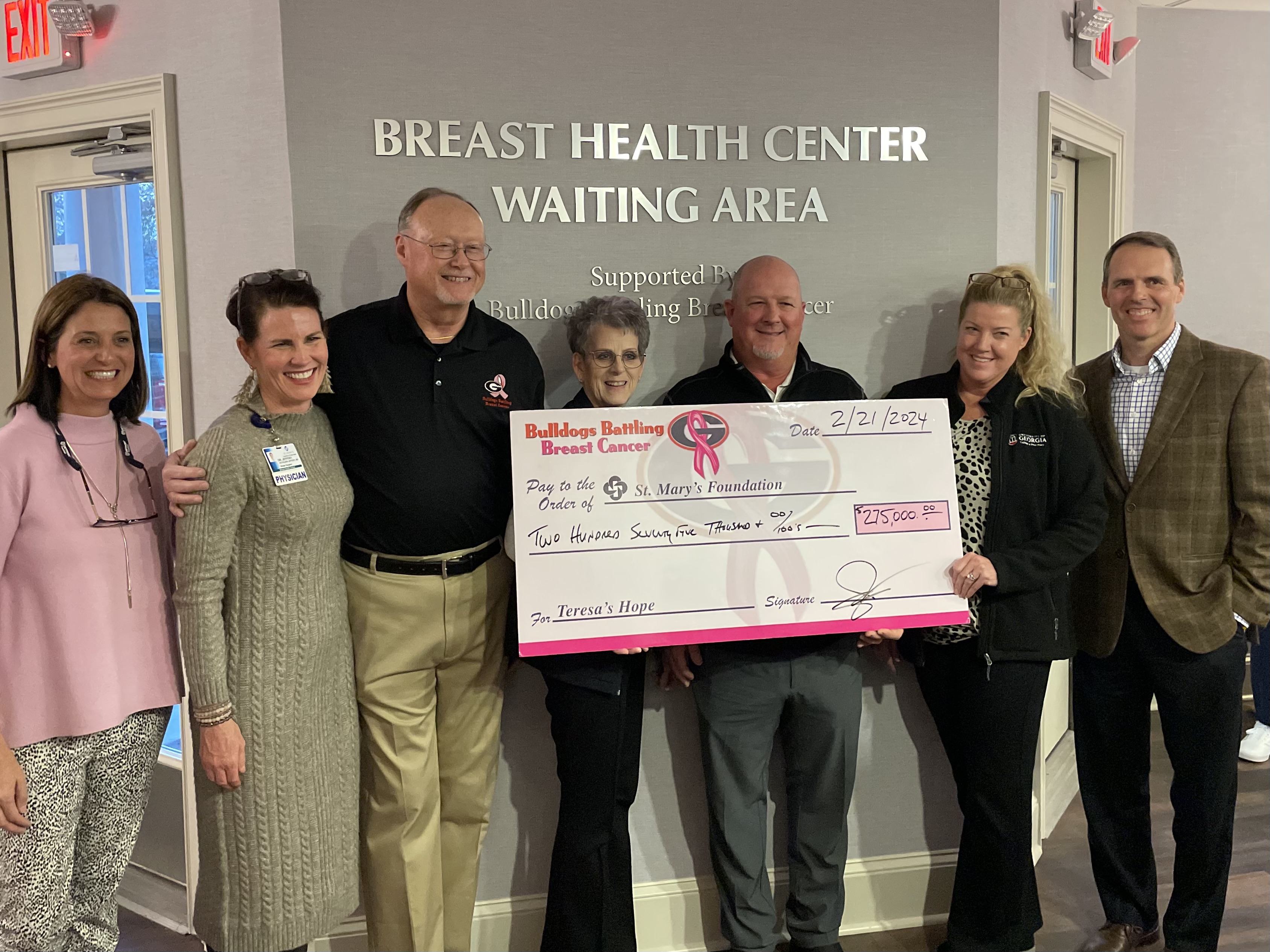 Bulldogs Battling Breast Cancer team handing large check to St. Mary's Breast health center.